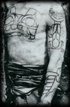 Click for more about this Haida Chief with a large tattoo of a Bear on chest and upper arms, and a Whale tattoo on his forearm.