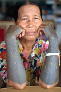 Kayan woman with hornbill, shoots of bamboo, guardian spirits, dragon-dog, and tuba root motifs that are all believed to repel evil spirits. 